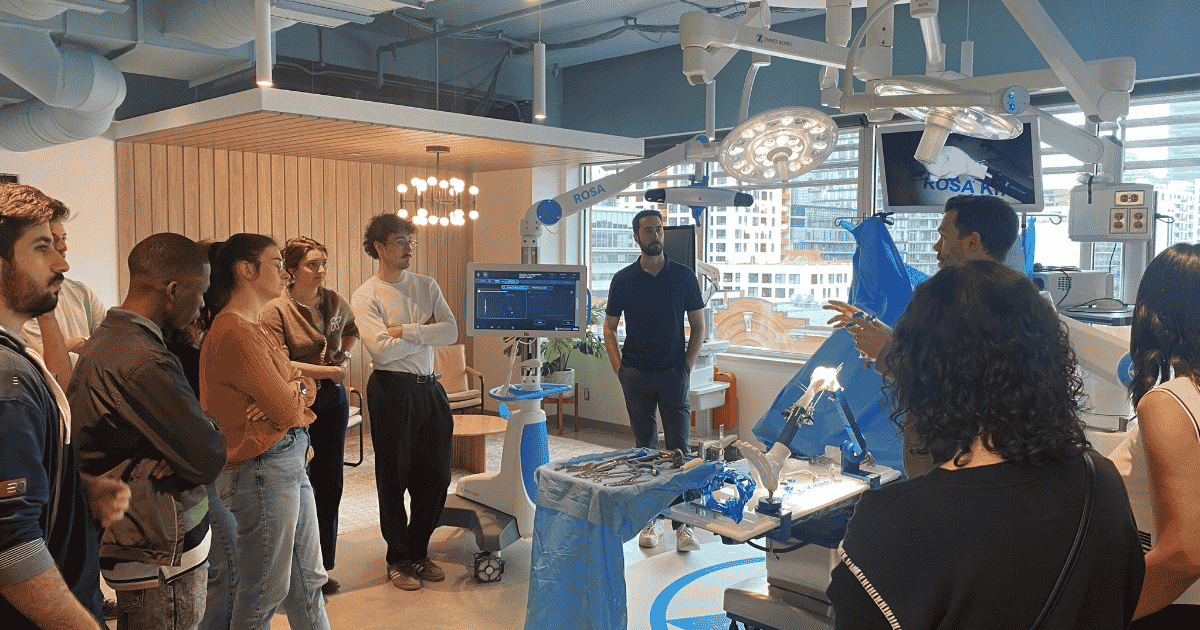 Un groupe d'étudiants assiste à une démonstration de technologie médicale avancée dans un environnement moderne et interactif.