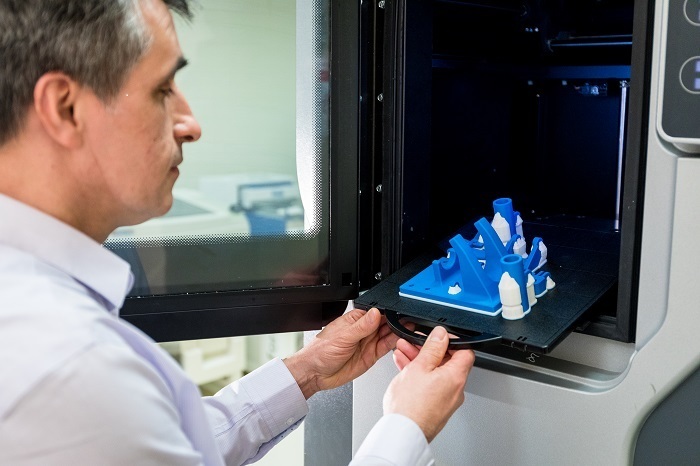 Impression 3D innovante en cours d'observation par un expert en technologie.
