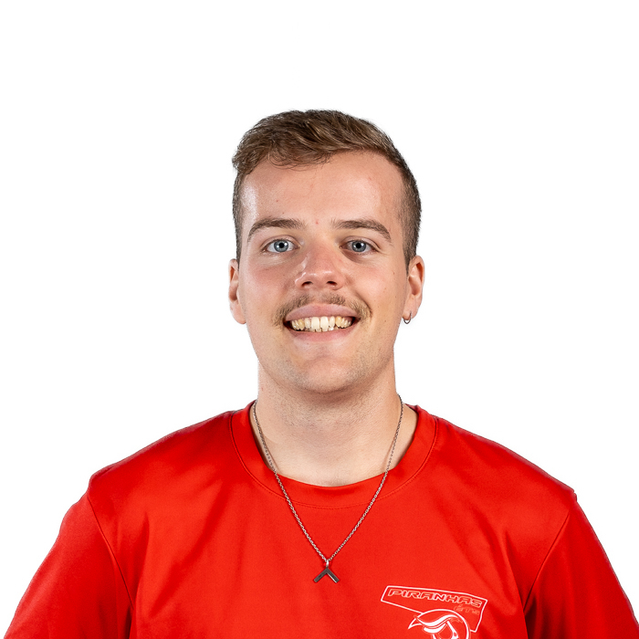 Étudiant souriant en maillot de sport bleu avec logo d'équipe.