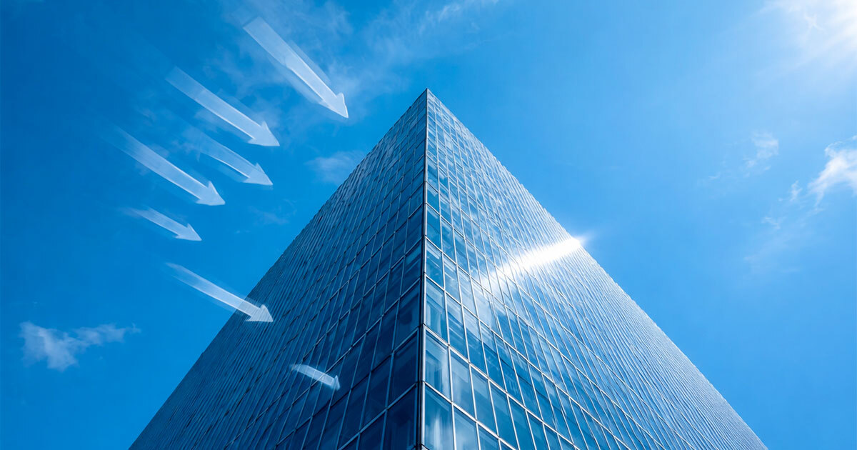 A sleek, modern building reaches towards a vibrant blue sky, showcasing innovative architecture and design.