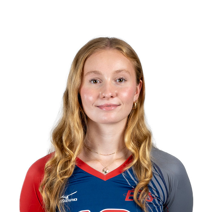 Athlète souriante en tenue de volleyball, arborant un maillot aux couleurs vibrantes, prête pour la compétition.